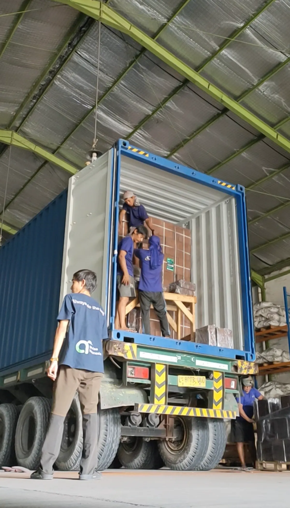Loading team stuffing a shipping container with palletized coco blocks
