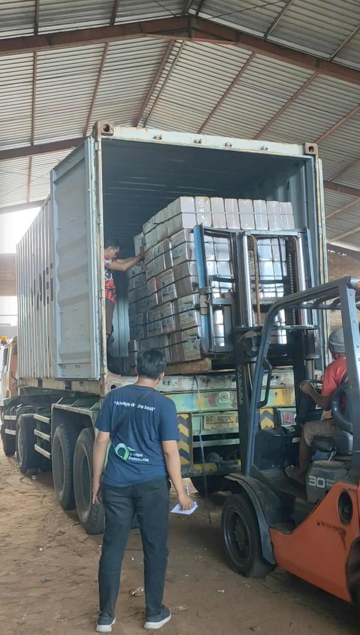 Forklift loading palletized coco blocks into a shipping container
