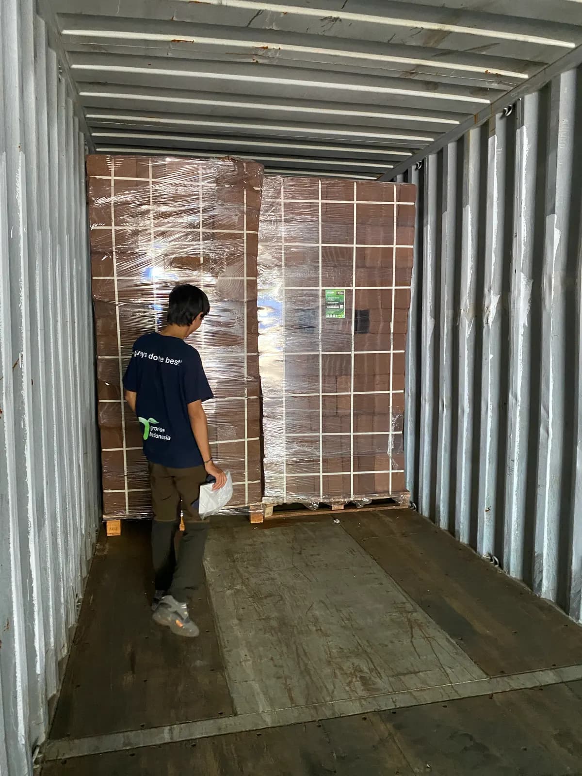 Final inspection of loaded pallets inside a shipping container